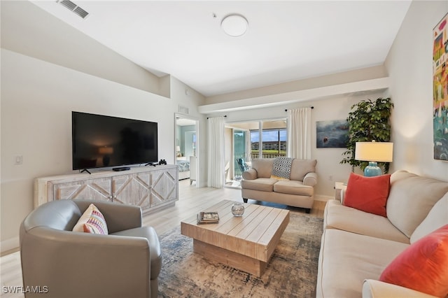 living room with light hardwood / wood-style flooring and vaulted ceiling