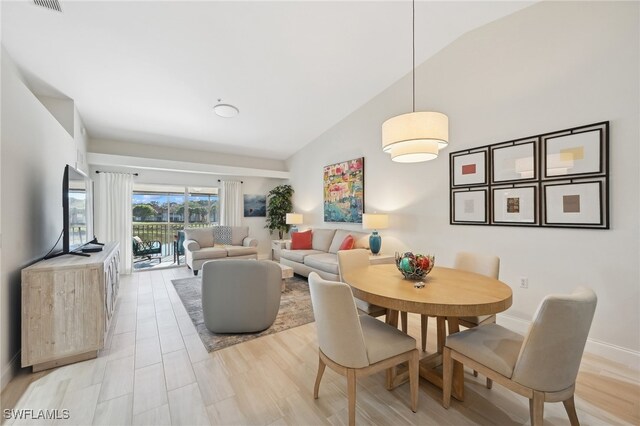 dining room featuring light hardwood / wood-style floors and lofted ceiling