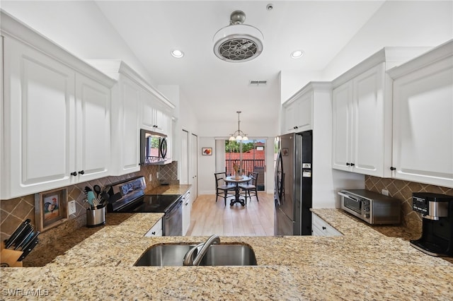 kitchen featuring white cabinetry, sink, stainless steel appliances, light hardwood / wood-style floors, and decorative backsplash