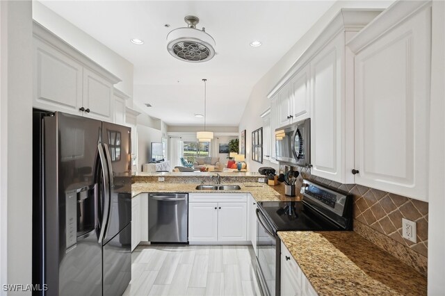 kitchen featuring white cabinets, decorative light fixtures, stainless steel appliances, and sink