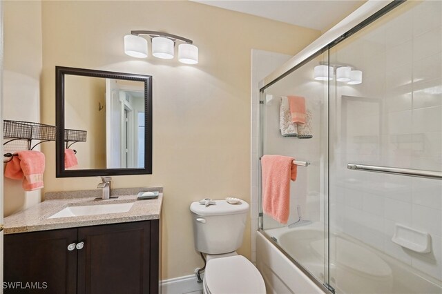 full bathroom with combined bath / shower with glass door, vanity, and toilet