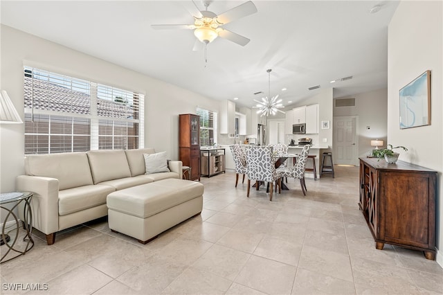 living room with ceiling fan with notable chandelier and light tile patterned flooring