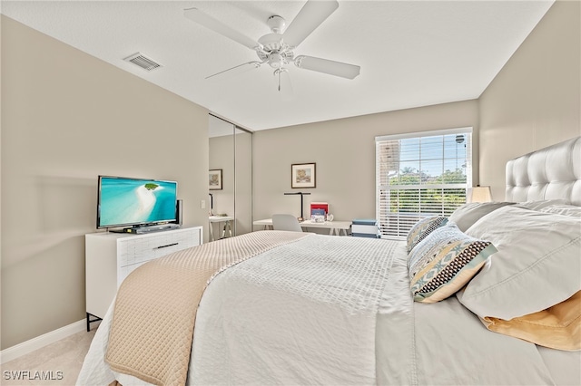 bedroom featuring ceiling fan, a closet, and light carpet