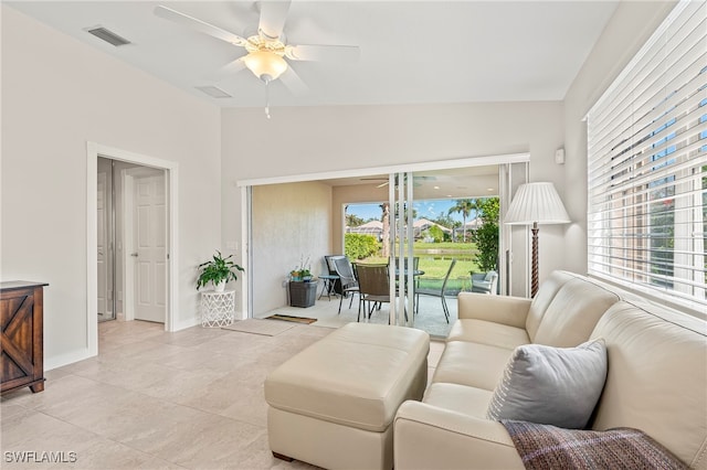 living room with ceiling fan, light tile patterned floors, a healthy amount of sunlight, and lofted ceiling