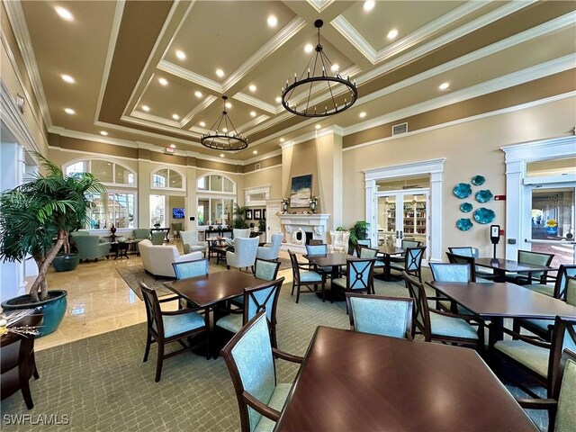 dining space featuring a high ceiling, a chandelier, coffered ceiling, and ornamental molding