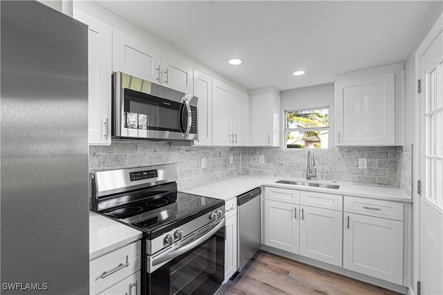 kitchen featuring white cabinets, sink, appliances with stainless steel finishes, and light hardwood / wood-style flooring