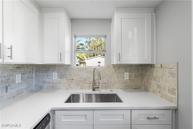 kitchen featuring white cabinets, decorative backsplash, dishwashing machine, and sink