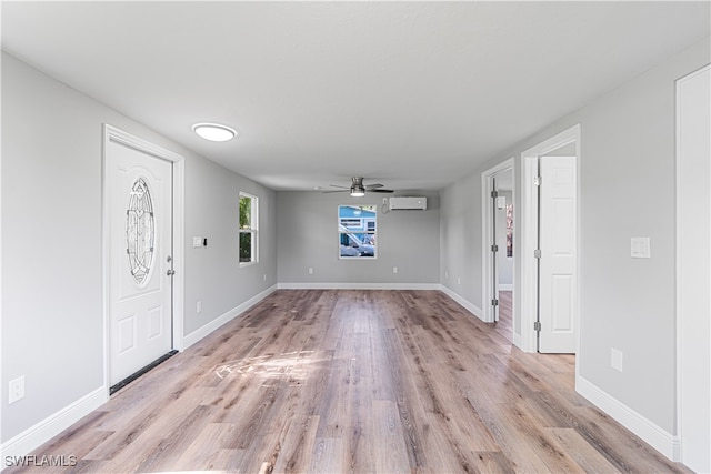 entrance foyer with ceiling fan, light hardwood / wood-style floors, and an AC wall unit