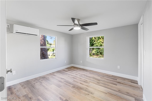 unfurnished room featuring light hardwood / wood-style floors, an AC wall unit, a wealth of natural light, and ceiling fan