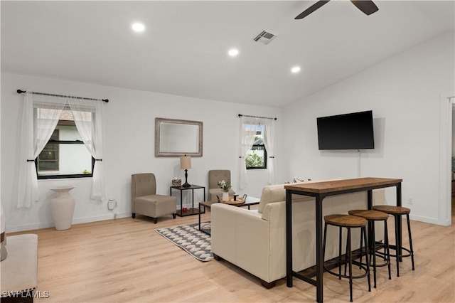 living room featuring light hardwood / wood-style floors, vaulted ceiling, and a wealth of natural light