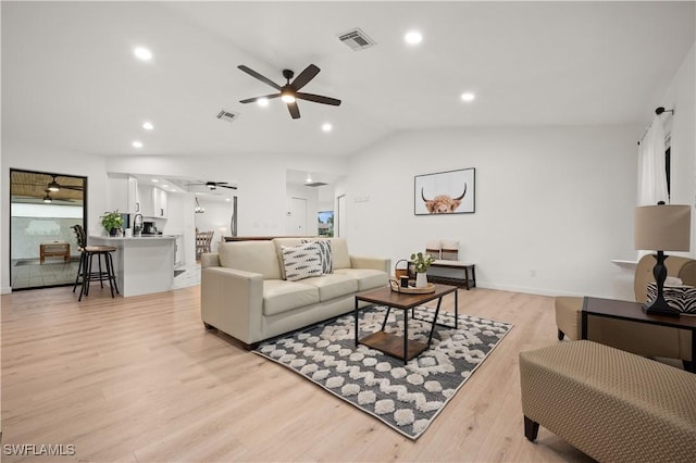 living room with ceiling fan, light hardwood / wood-style floors, and lofted ceiling