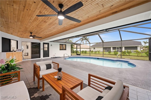 view of pool featuring a patio area, outdoor lounge area, and glass enclosure