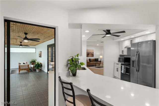 kitchen featuring stainless steel refrigerator with ice dispenser, white cabinetry, kitchen peninsula, wooden ceiling, and stove