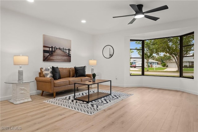 living room with light wood-type flooring and ceiling fan