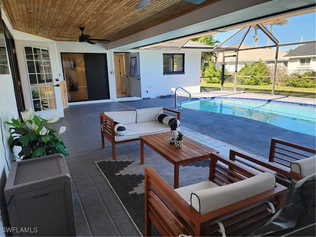 view of pool with ceiling fan, a patio area, a lanai, and an outdoor living space