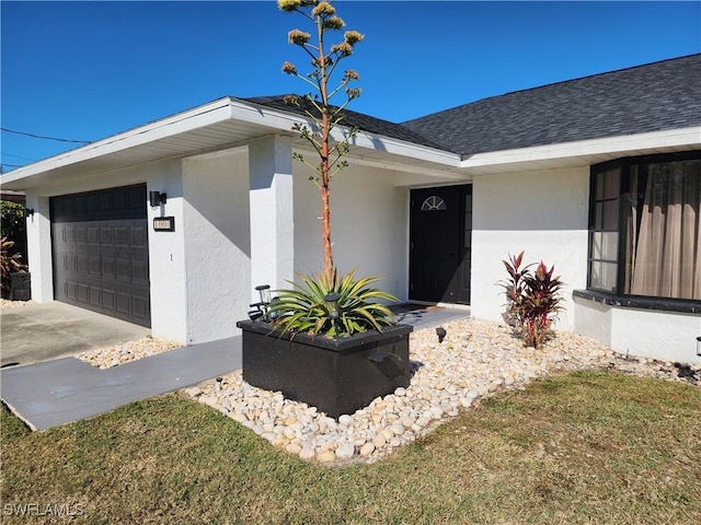 exterior space featuring roof with shingles, driveway, an attached garage, and stucco siding