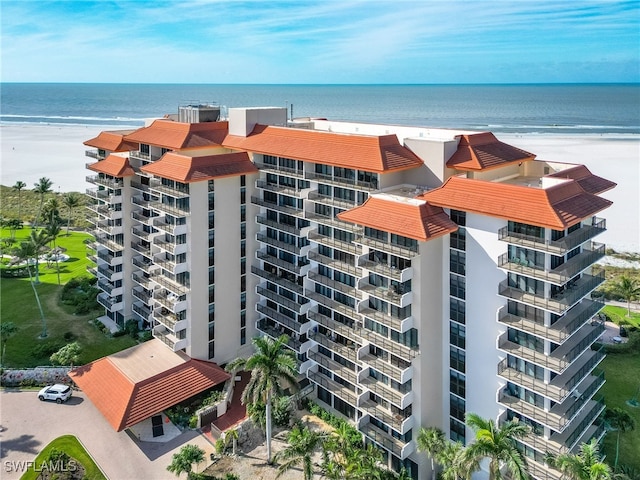 view of building exterior with a water view and a view of the beach