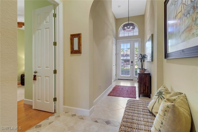 foyer featuring a notable chandelier, a high ceiling, and light hardwood / wood-style flooring