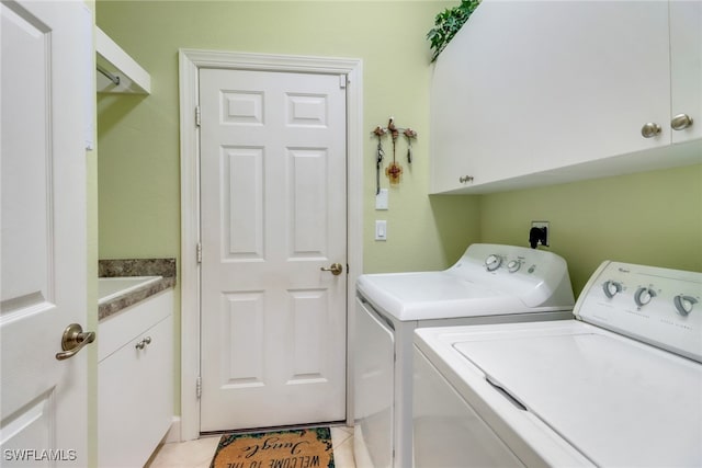 washroom with washer and dryer, cabinets, and light tile patterned floors