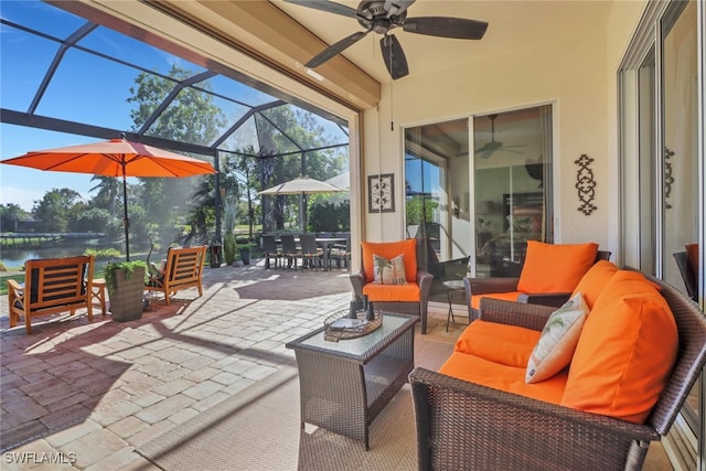 view of patio / terrace with a lanai, an outdoor living space, ceiling fan, and a water view