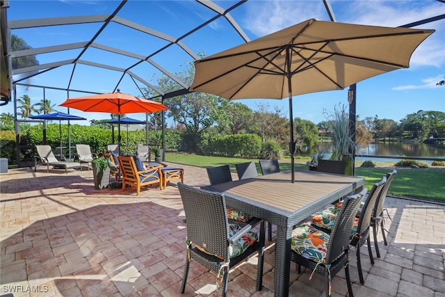 view of patio / terrace featuring a lanai and a water view