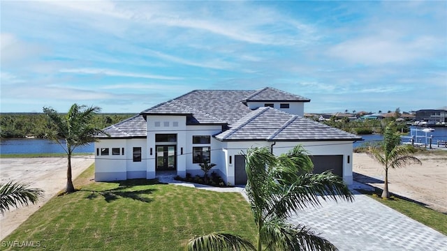 view of front facade featuring a water view, a front yard, and a garage