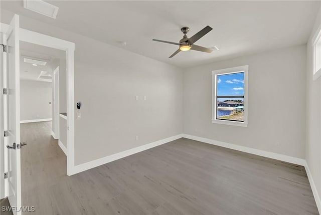 spare room with ceiling fan, baseboards, and wood finished floors