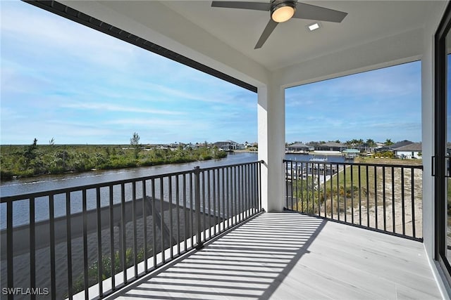 balcony featuring ceiling fan and a water view