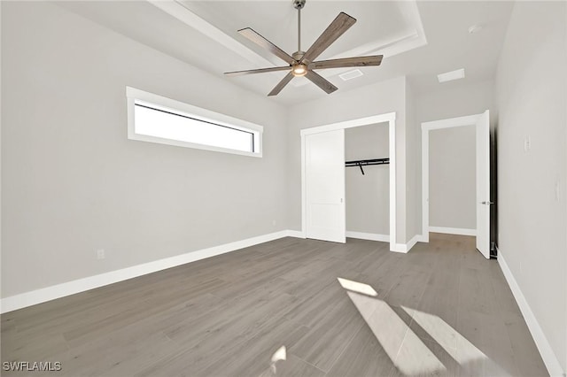 unfurnished bedroom with a closet, baseboards, and wood finished floors