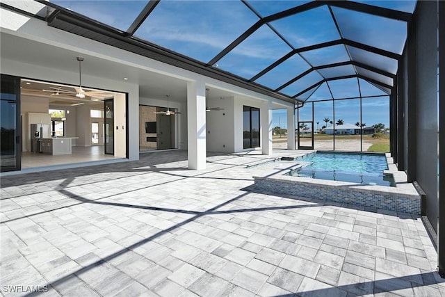 view of pool with a patio, glass enclosure, and ceiling fan