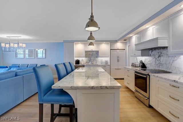 kitchen with a center island, hanging light fixtures, premium range hood, white fridge, and stainless steel electric stove