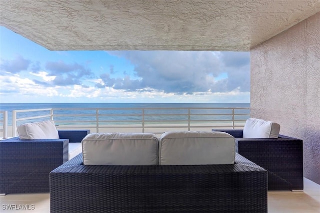 balcony with a water view and a beach view