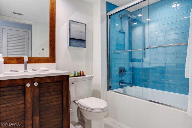 full bathroom featuring shower / bath combination with glass door, vanity, and toilet