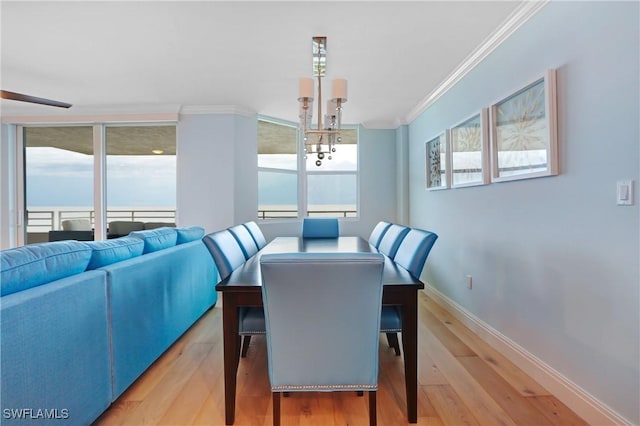 dining room featuring hardwood / wood-style flooring, crown molding, and a wealth of natural light