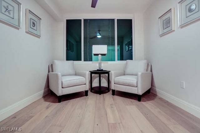 sitting room with ceiling fan and light hardwood / wood-style flooring