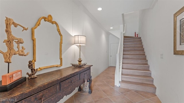 staircase with tile patterned floors and ornamental molding