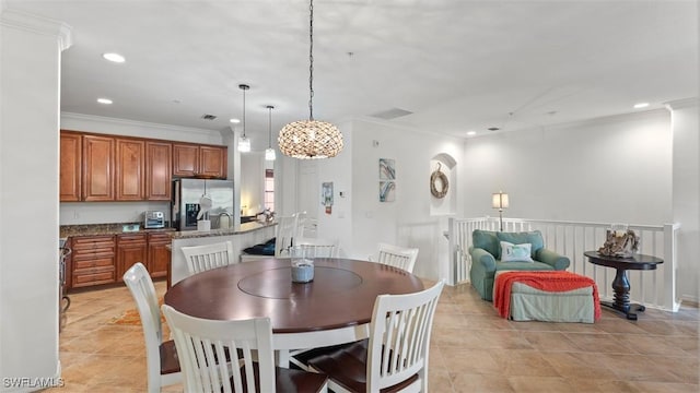 dining space featuring crown molding and light tile patterned flooring