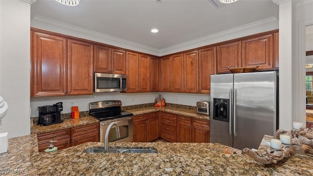 kitchen with light stone countertops, sink, ornamental molding, and appliances with stainless steel finishes