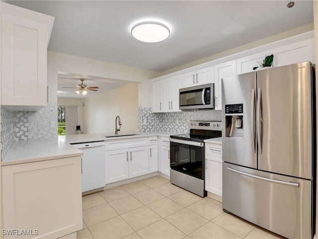 kitchen featuring decorative backsplash, stainless steel appliances, white cabinetry, and sink