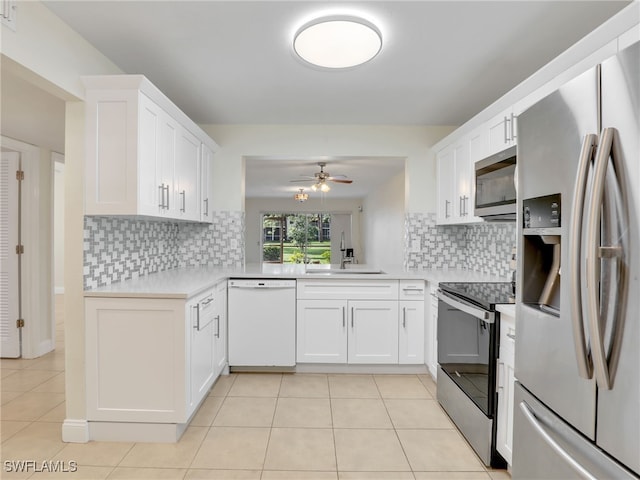 kitchen featuring tasteful backsplash, white cabinetry, and stainless steel appliances