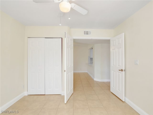 unfurnished bedroom featuring ceiling fan, a closet, and light tile patterned floors