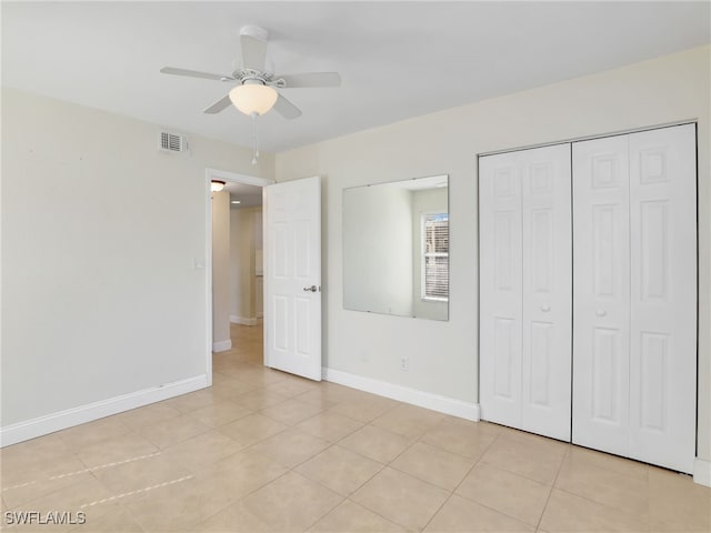 unfurnished bedroom featuring ceiling fan, light tile patterned flooring, and a closet