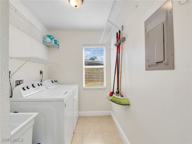 washroom featuring washing machine and dryer, electric panel, light tile patterned flooring, and sink