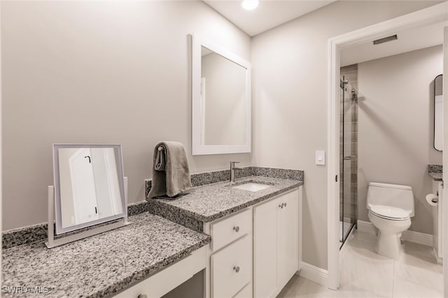 bathroom with tile patterned flooring, vanity, a shower with shower door, and toilet