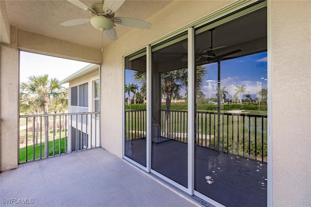 unfurnished sunroom with ceiling fan