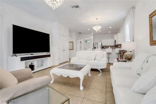 living room with light tile patterned floors and an inviting chandelier