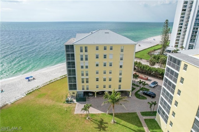 drone / aerial view featuring a water view and a beach view