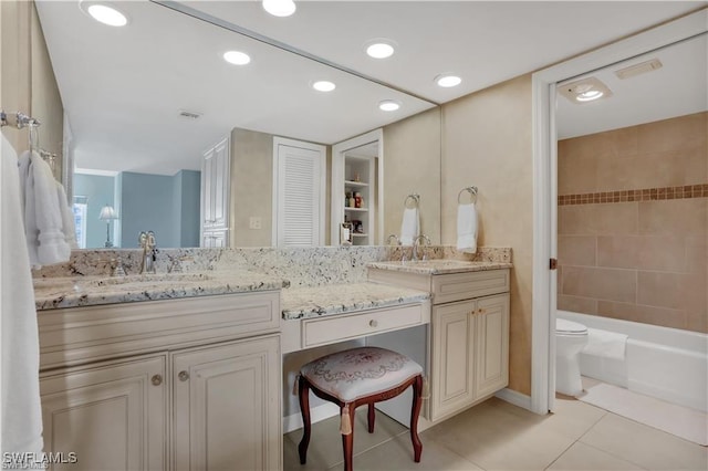 bathroom with toilet, vanity, and tile patterned floors