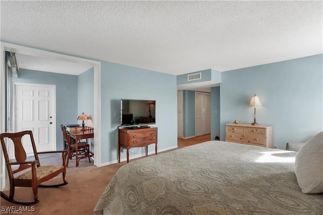 bedroom with a textured ceiling and light carpet