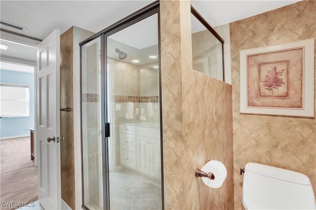 bathroom with a shower with shower door and toilet